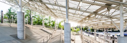 Rapid transit station in Ohio featuring sloped Kalwall translucent canopy over cinderblock columns and greenery in background