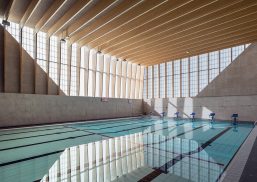 British School of Brussels pool enclosure featuring wooden ceiling beams and Kalwall translucent curtain wall system