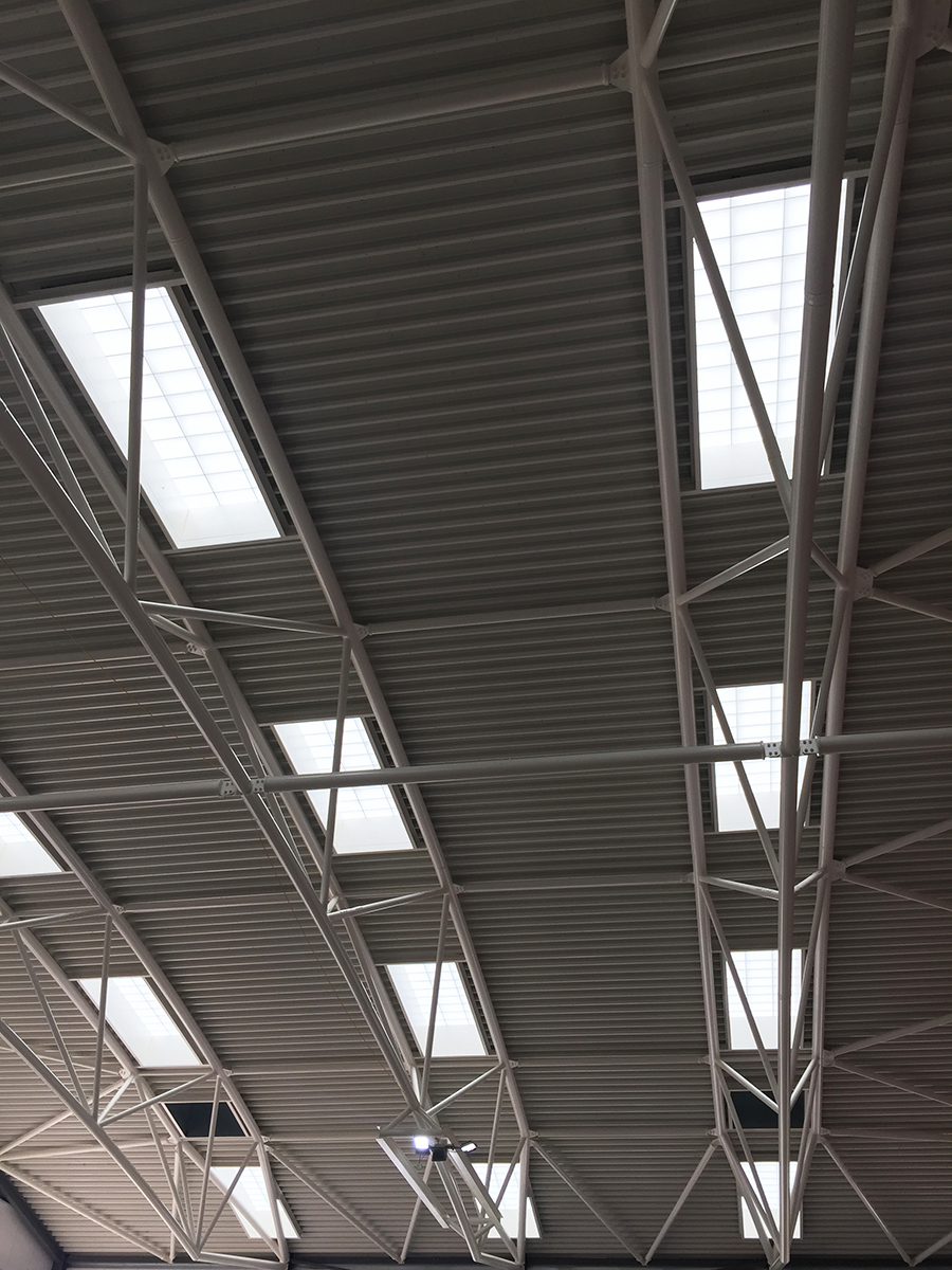 Close-up of Kalwall s-line skylights among metal piping in ceiling featured in the Cheltenham Ladies' College interior.