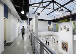 Elgin Artspace Lofts building featuring man walking on upper level while people walk below under Kalwall skyroof®