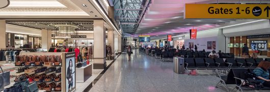 Heathrow Airport Terminal 4 interior with Kalwall clearspan™ skylight system above gate area with purple-hued lights