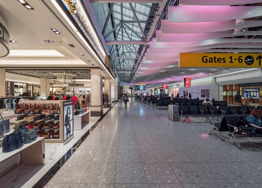 Heathrow Airport Terminal 4 interior with Kalwall clearspan™ skylight system above gate area with purple-hued lights