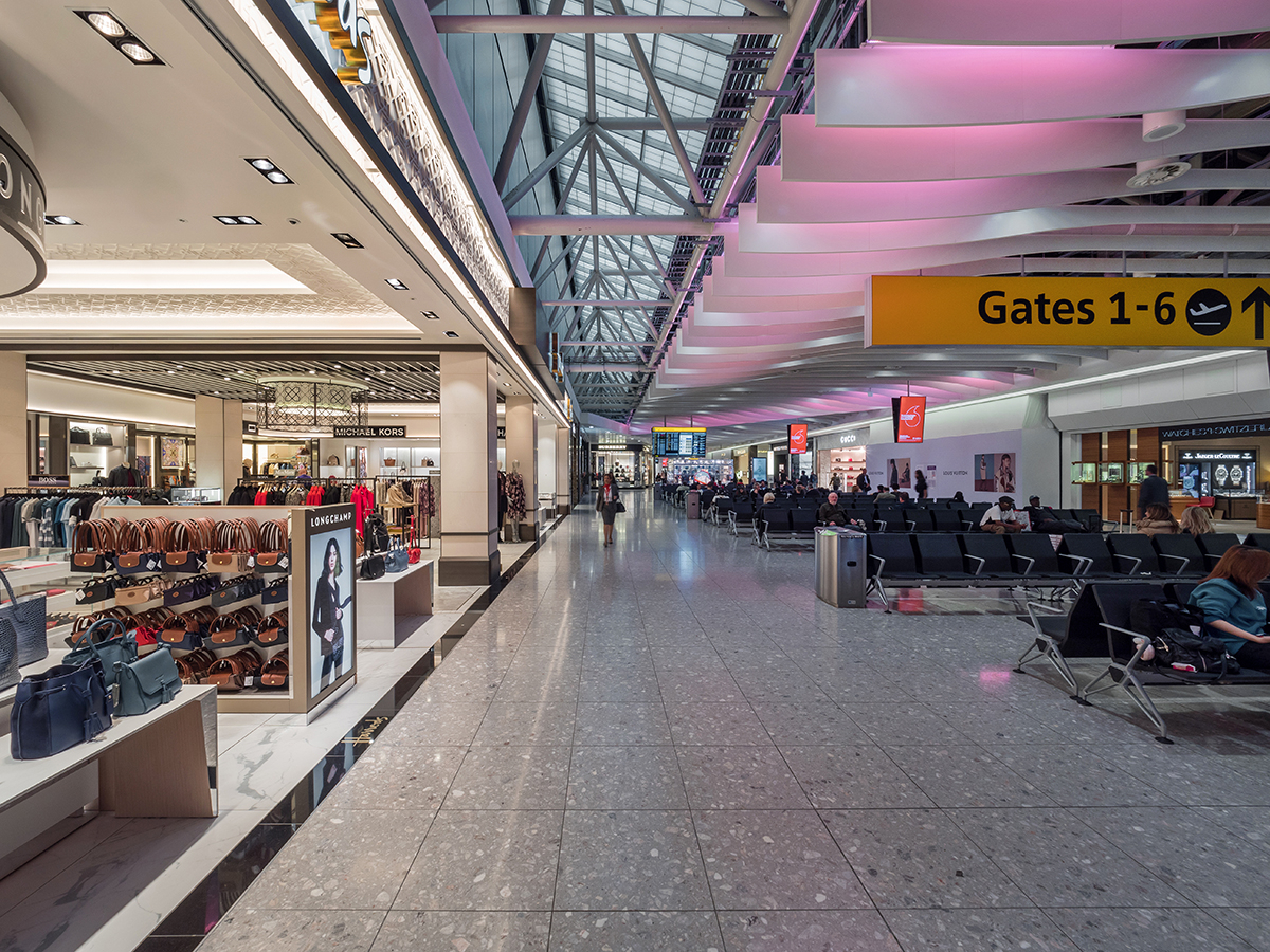 Heathrow Airport Terminal 4 interior with Kalwall clearspan™ skylight system above gate area with purple-hued lights