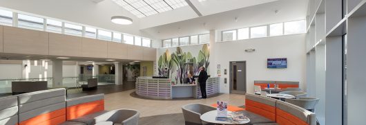 Benenden Hospital atrium and lounge area with tables and chairs featuring skylight windows with Kalwall structural panels