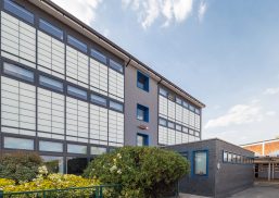 Featherstone High School exterior featuring Kalwall unitized curtain wall system for view to outside with flowers in front