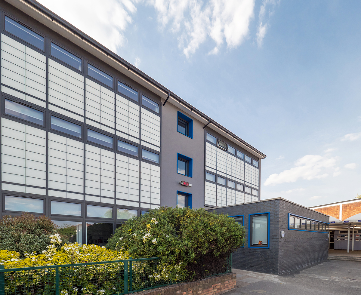 Featherstone High School exterior featuring Kalwall unitized curtain wall system for view to outside with flowers in front