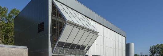 Fermilab exterior shot with unitized curtain wall system with one set of wall panels opening to reveal inside