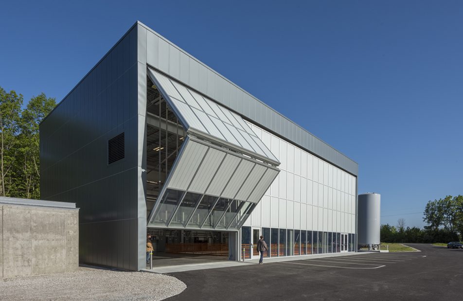 Fermilab exterior shot with unitized curtain wall system with one set of wall panels opening to reveal inside