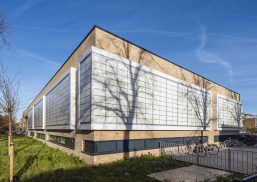 Segbroek College exterior set against blue sky with Kalwall translucent FRP panels wrapping sections of brick building