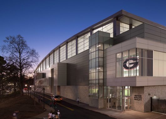 Nighttime exterior of University of Georgia indoor athletic facility featuring Kalwall FRP panels on upper third of building