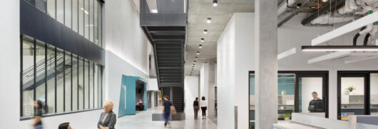 Interior of California Air Resources Board lobby filled with people, a staircase and interior windows.