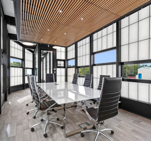 Interior of the Frank's Ice Cream office with a conference table and chairs set among a Kalwall facade with unitized windows.