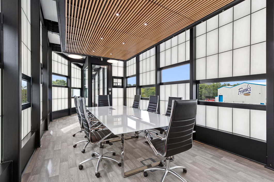 Interior of the Frank's Ice Cream office with a conference table and chairs set among a Kalwall facade with unitized windows.